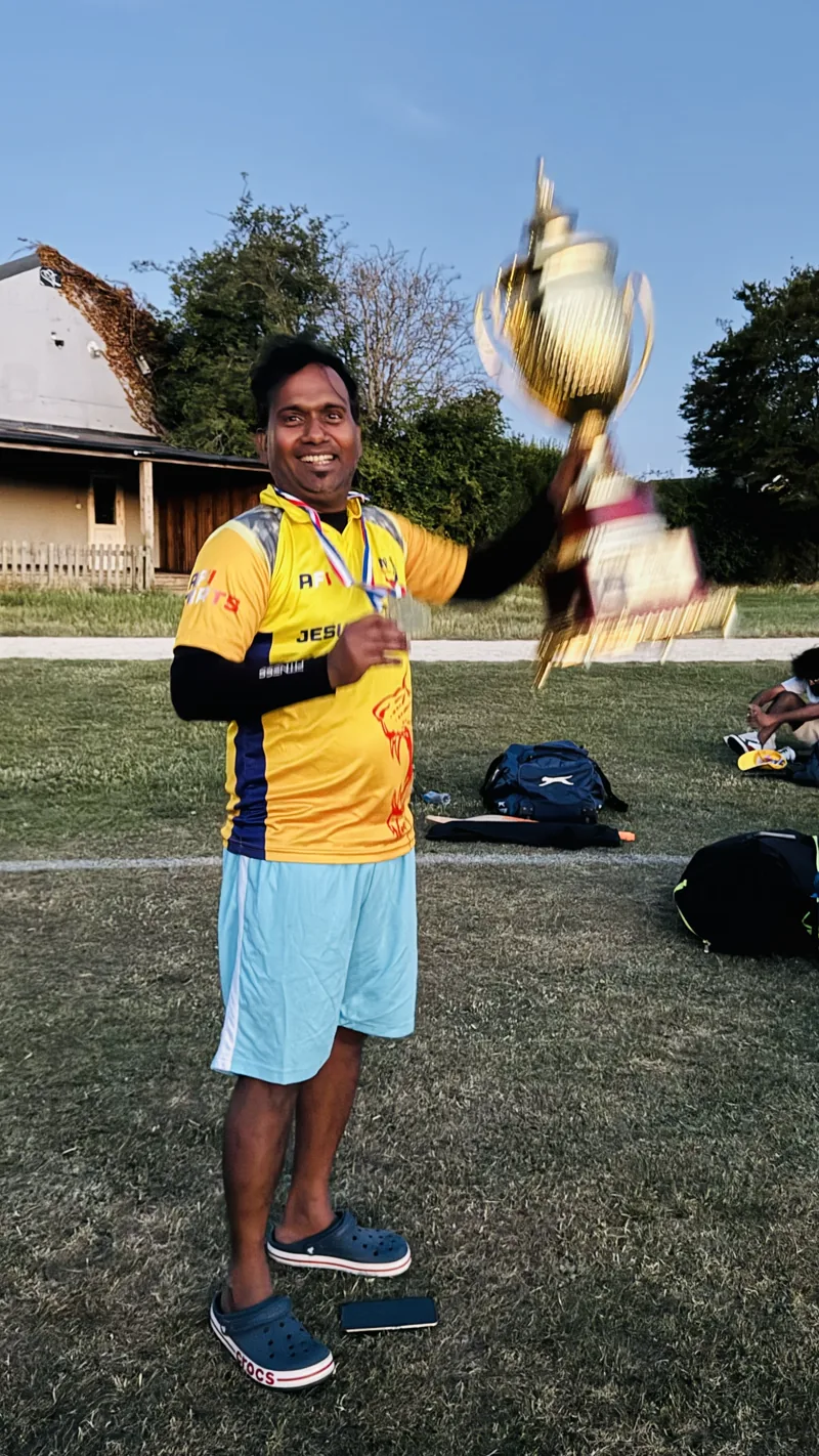 Jebasingh celebrating with a cricket trophy