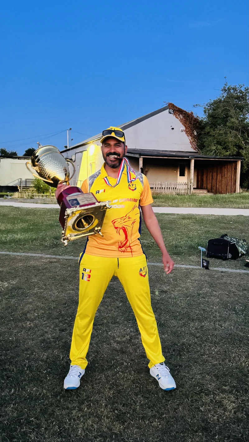 Syam holding a cricket trophy